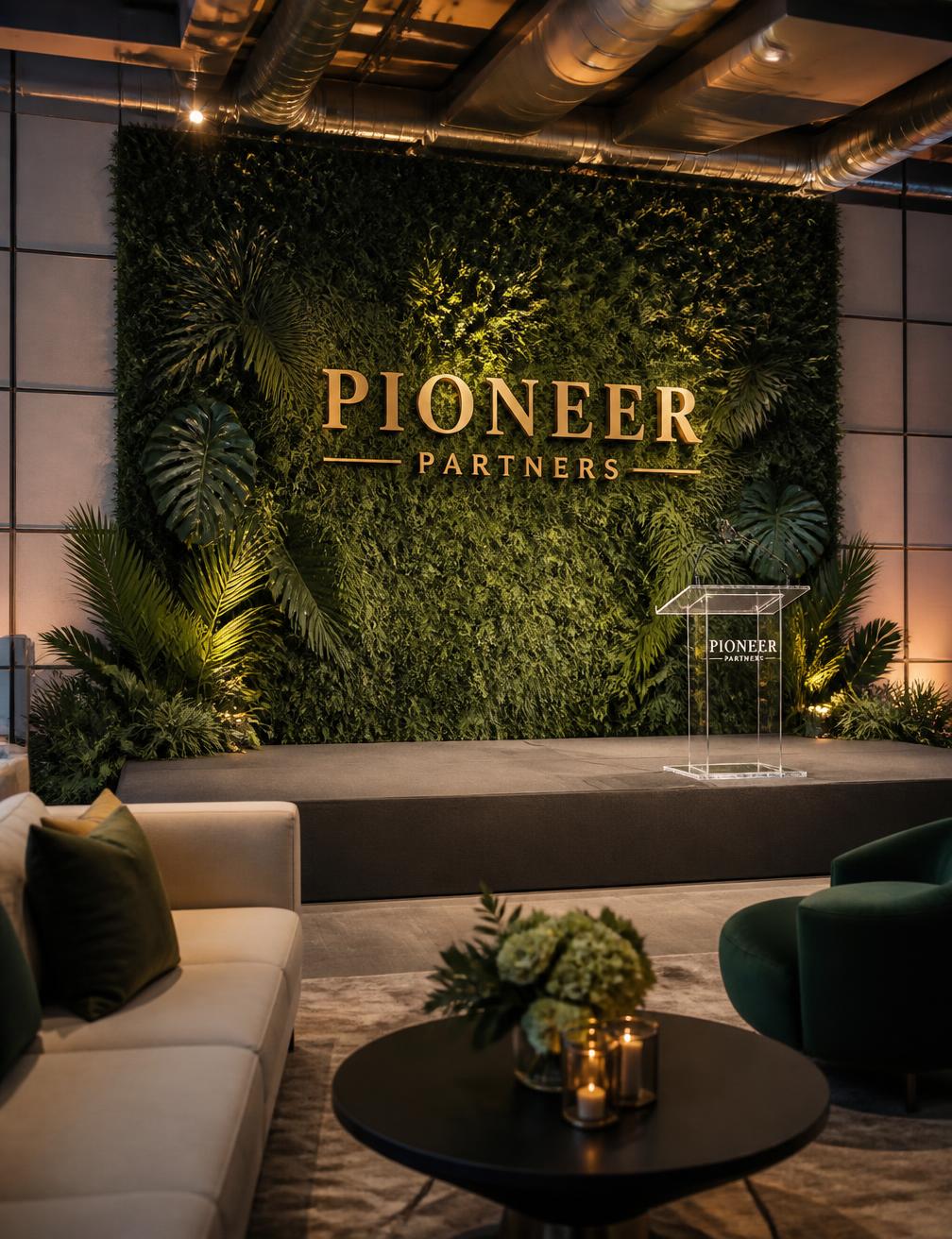 Corporate event stage with greenery wall and lounge seating